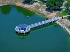 An aerial view of a circular observation tower with a walkway extending into a lake. - 4BR Lexington Home – Pool, Fishing Pond, Firepit, Sleeps 8 (Lexington)