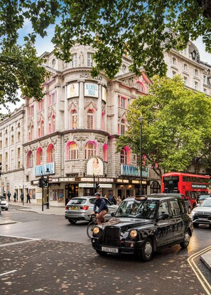 A historic building with a theater marquee, a red double-decker bus, and a black car parked on the street. - SomersetHouseSuites by Aureva Residences (London)