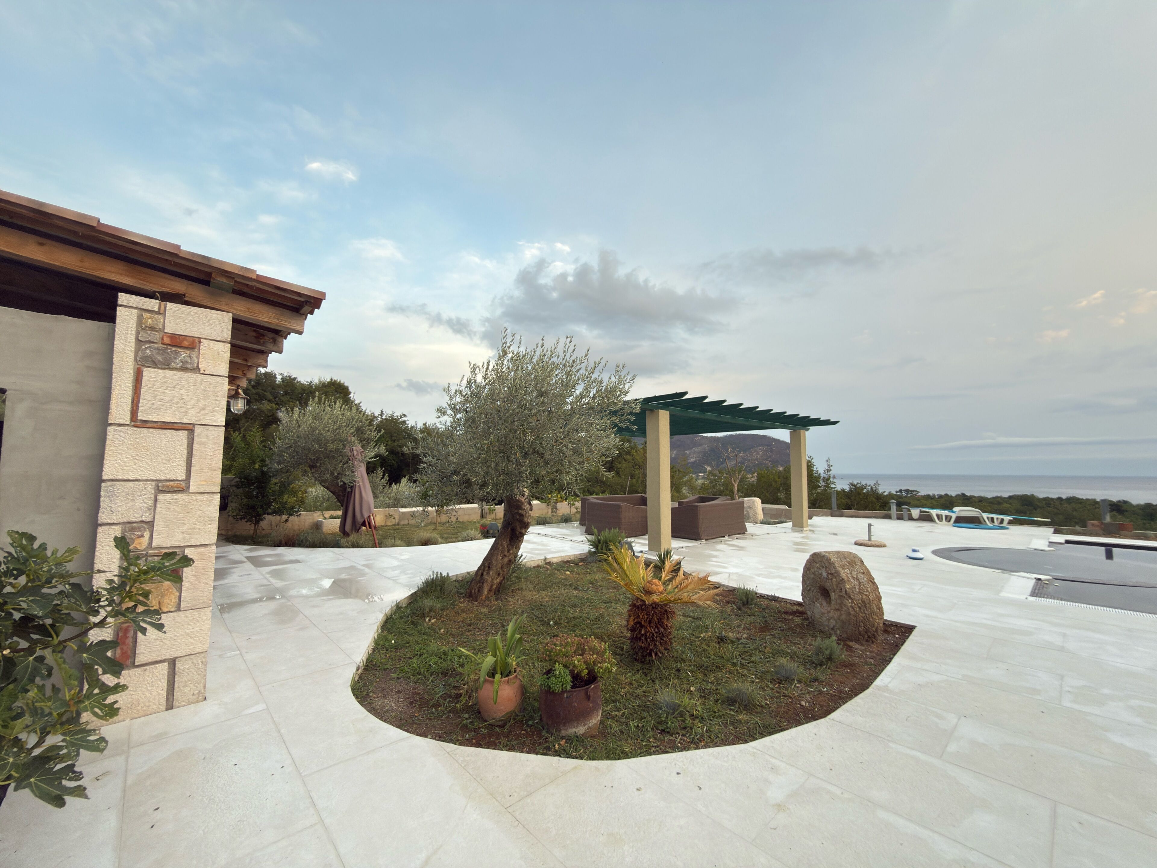 Un espace patio agrémenté d’une pergola, de sièges et de plantes en pot.