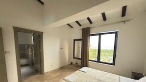 A bedroom with a bed, a window with a view, a bathroom, and a door leading to another room. - Paštrovići Stone Retreat with Pool,Jacuzzi & Adriatic Sea Views (Kaluđerac)