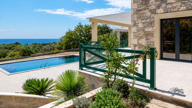 A swimming pool with a stone wall and a view of the sea. - Paštrovići Stone Retreat with Pool,Jacuzzi & Adriatic Sea Views (Kaluđerac)