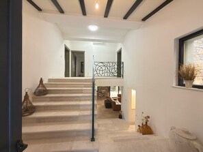 A staircase leading to a second-floor area with a view of the outdoors.