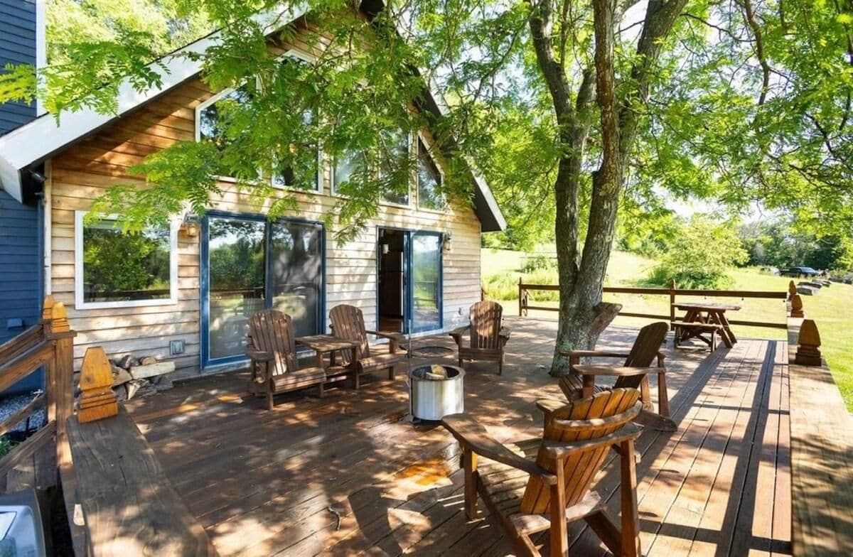 A wooden deck with outdoor seating and a fire pit.