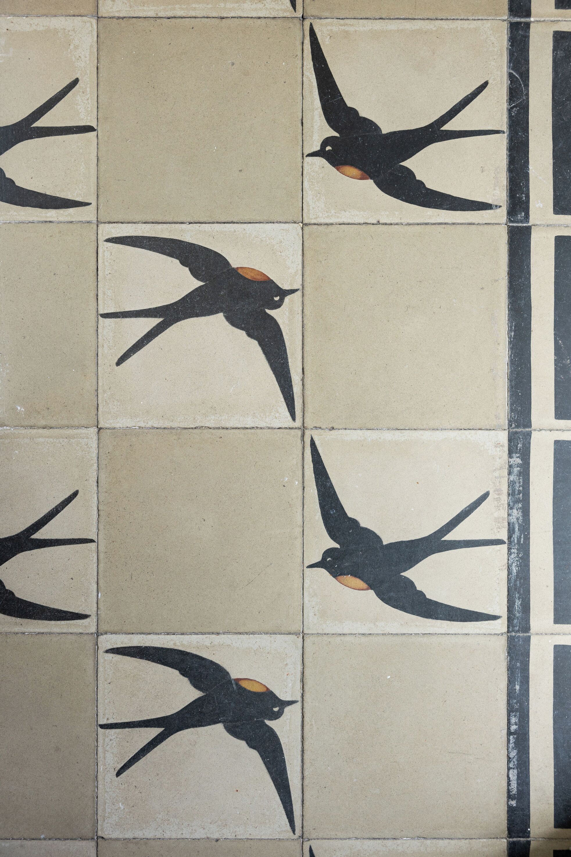 Un pavimento piastrellato con decorazioni a tema uccelli.