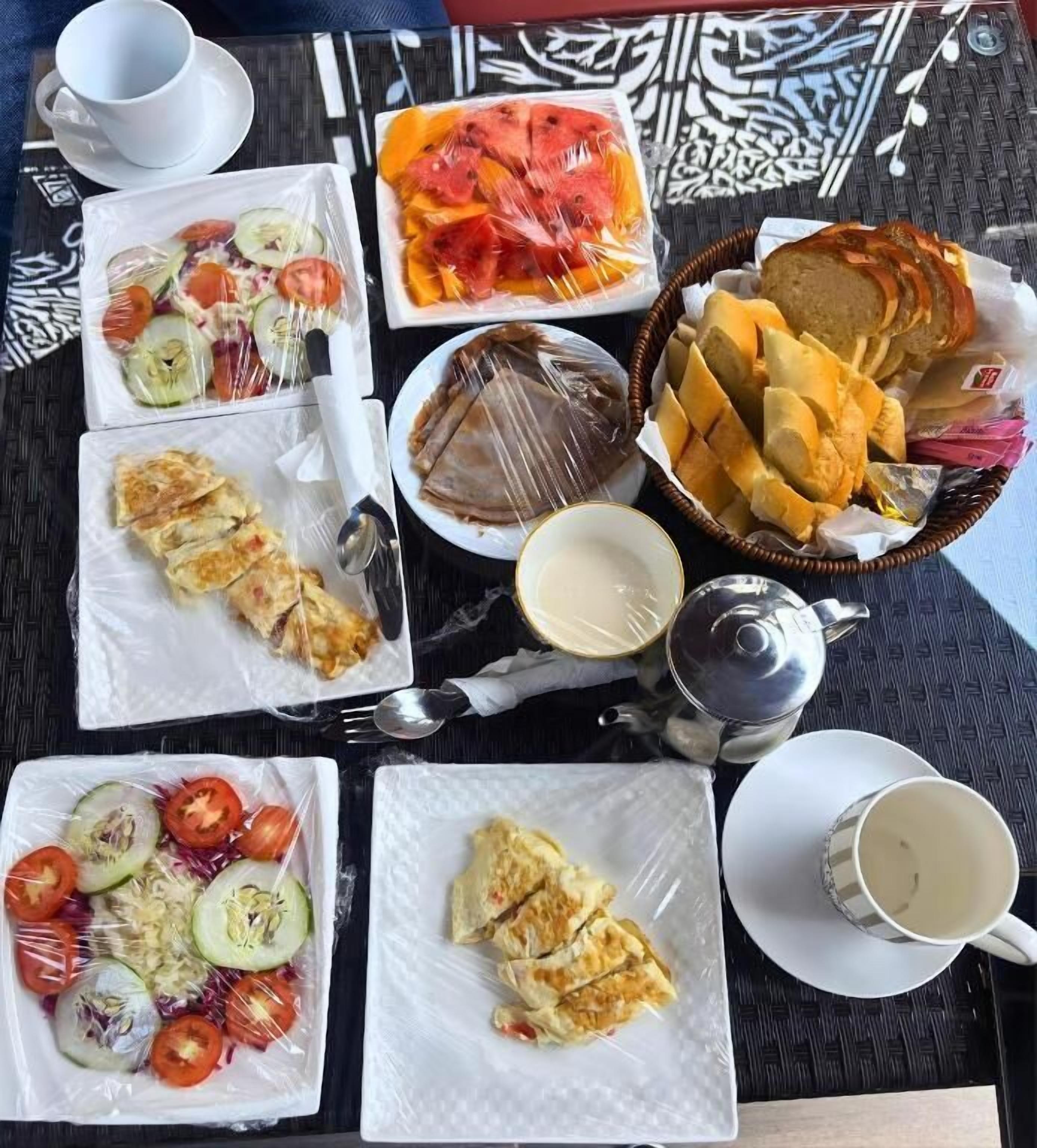 Una mesa con diferentes alimentos, una tetera y tazas.