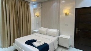 Un dormitorio moderno con cama, mesitas de noche, lámpara de pared y lámpara de techo.