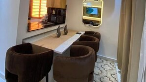 Un espacio habitable compacto con comedor, cocina y televisor montado en la pared.