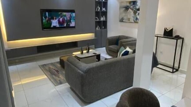 Una sala moderna con un sofá, un sillón y una mesa de centro.