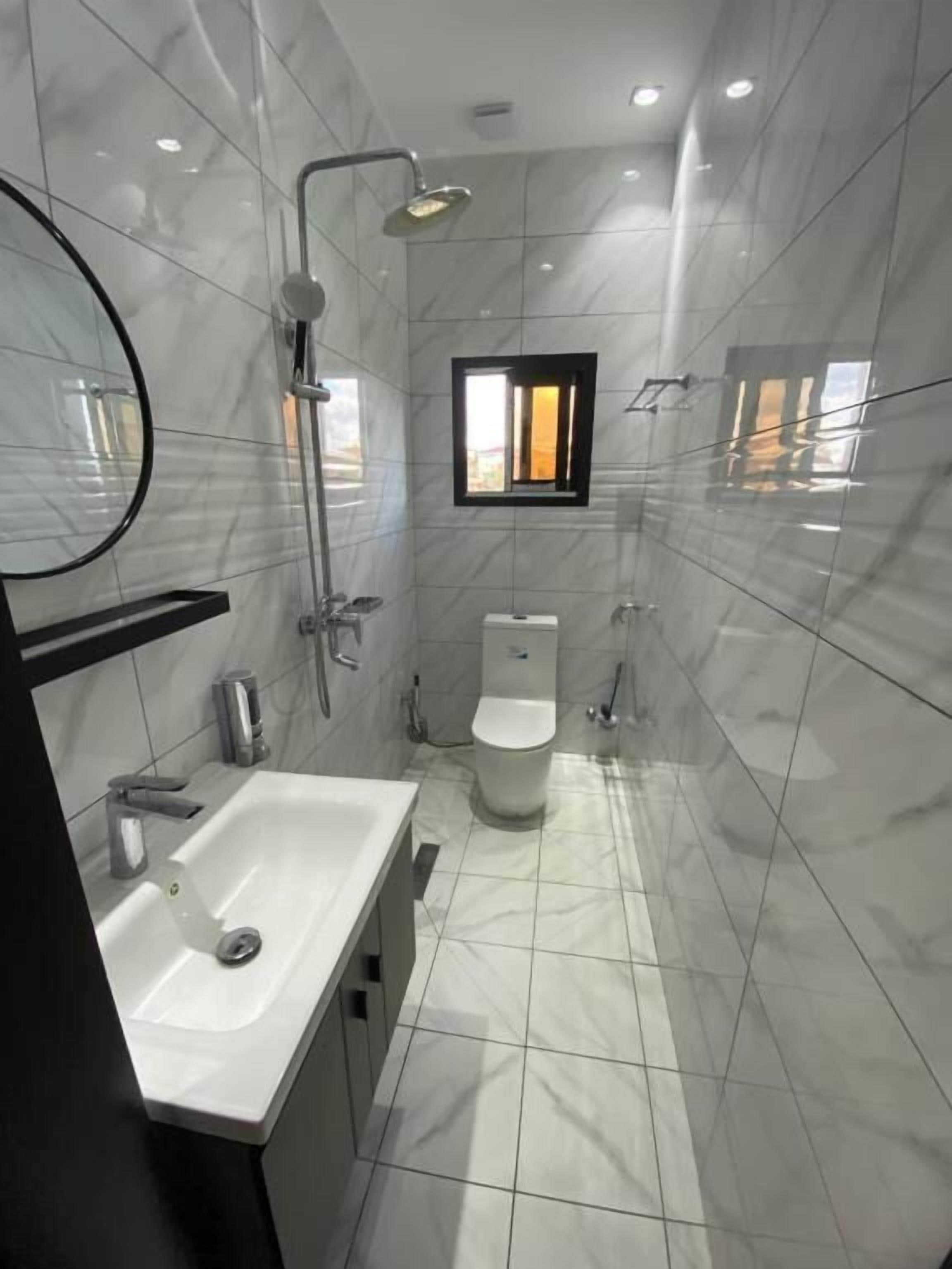 Un baño moderno con lavamanos, inodoro y ducha.
