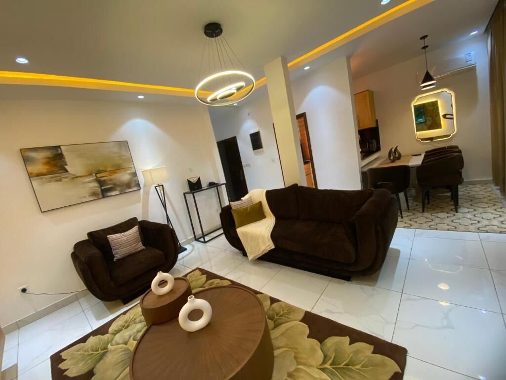 Uma sala de estar moderna com sofá, mesa de centro e área de jantar com mesa e cadeiras.