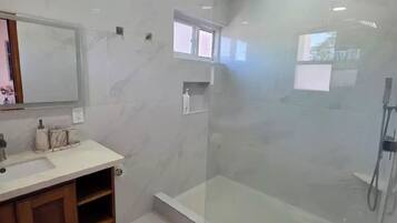 Een douche, handdoeken, zeep, toiletpapier