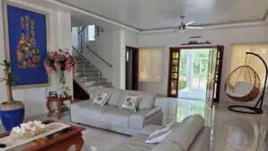 Una sala moderna con un sofá, una mesa de centro y una silla colgante.