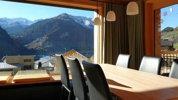 Ein Essbereich mit Bergblick, Holzboden und modernen Stühlen.