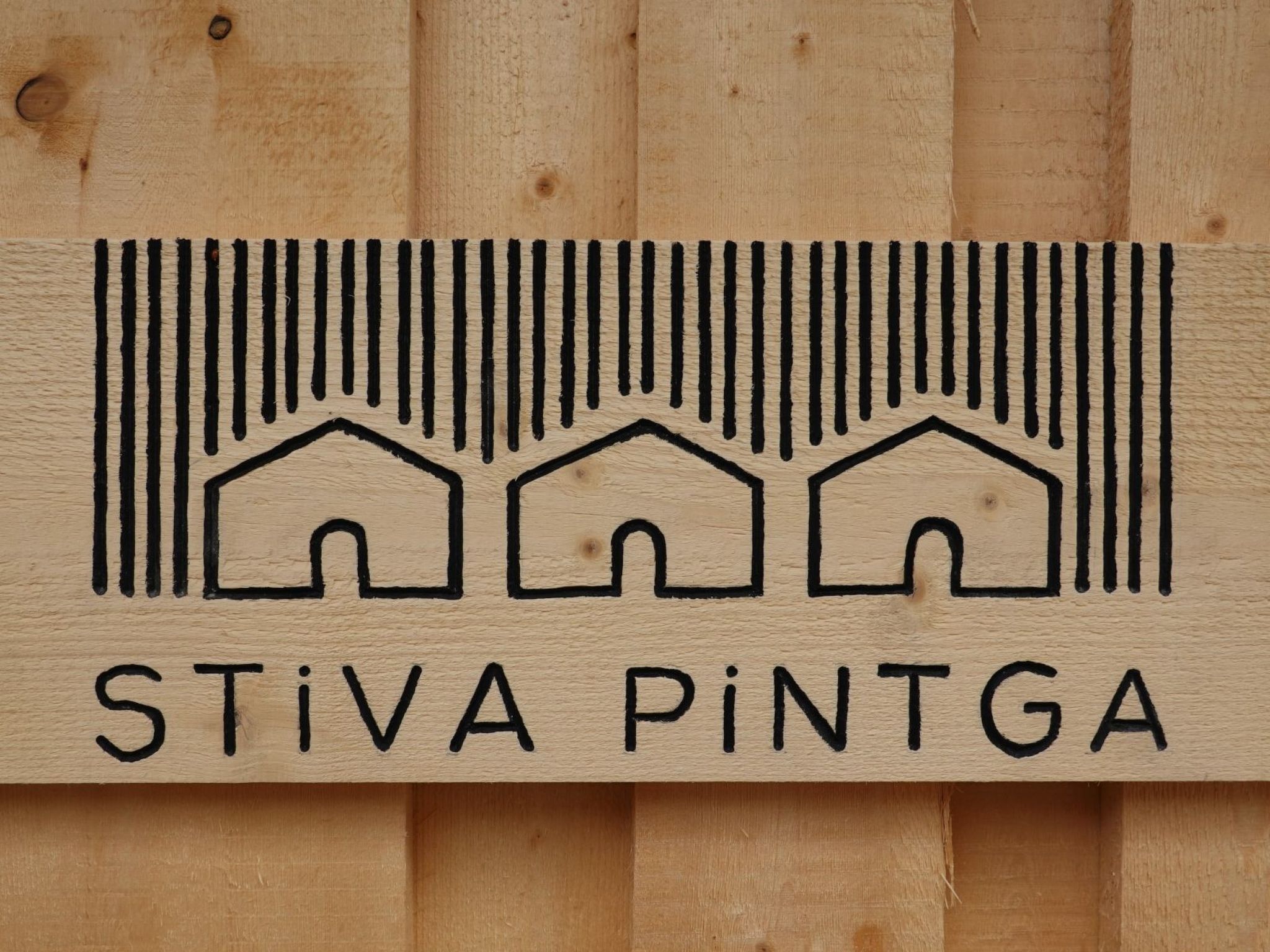 Uma placa de madeira com um design de código de barras e o texto 'STiVA PiNTGA'.