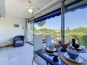 Ein Balkon mit Essbereich, Deckenventilator und Blick auf die Landschaft.