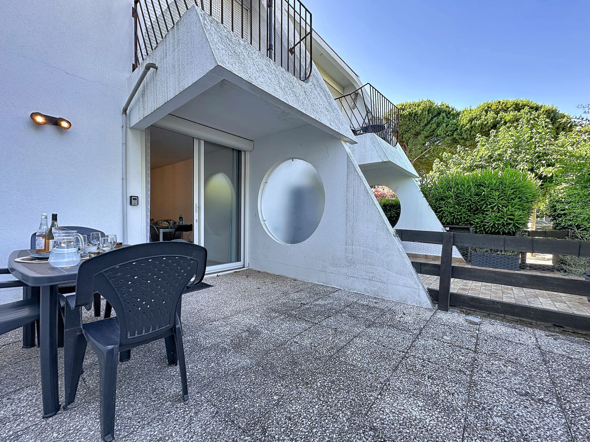 Un bâtiment moderne doté d’une conception architecturale unique, comprenant un toit en pente et une fenêtre circulaire.
