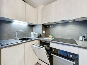 A modern kitchen with a dishwasher, stove, and a coffee maker. - Dixie Land by Interhome (La Grande Motte)