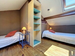 A small, cozy room with two single beds, a blue metal shelf, and a wooden ladder. - L'Estuaire by Interhome (Saint Brevin les Pins)