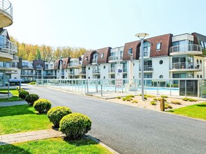 Ein modernes Hotel mit mehreren Etagen, Balkonen und einem Swimmingpool.