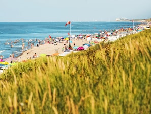 Ein Strand mit Menschen, Sonnenschirmen und Booten.