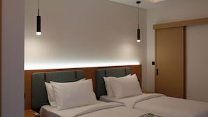 Una habitación de hotel con cama, mesitas de noche y un armario.
