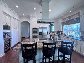 A modern kitchen with white cabinetry, stainless steel appliances, and a granite countertop. - Tremendous 4-bedroom house in sunny Wine Country Temecula (Temecula)