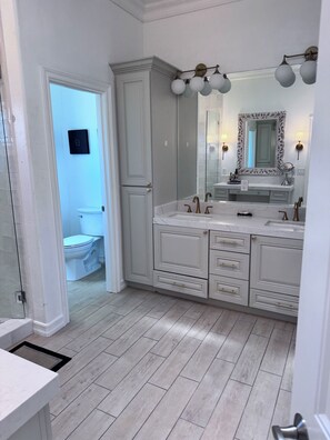 Un bagno con doppio lavabo, un ampio specchio e zona doccia.