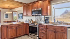 Una cucina moderna con mobili in legno, elettrodomestici in acciaio inossidabile e un'ampia finestra con vista.