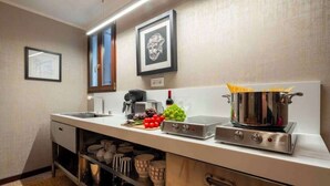A kitchen with a stainless steel range, a coffee machine, and a pot of spaghetti. - Grand Canal Palazzo Retreat with Private Canal Views in San Marco (Venezia)