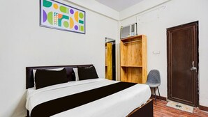 Een slaapkamer met een bed, een houten garderobe, een stoel en een deur.
