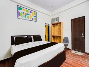Ein Schlafzimmer mit einem Bett, einem Holzschrank, einem Stuhl und einer Tür.