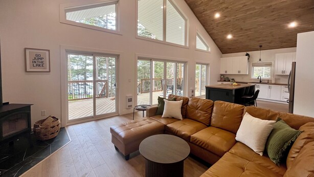 A spacious living area with a large L-shaped brown leather sofa, a round coffee table, and a fireplace.