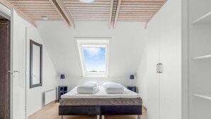 A bedroom with a bed, a window, a door, and a wooden ceiling. - "Lotte" - 1.5km from the sea by Interhome (Skagen)