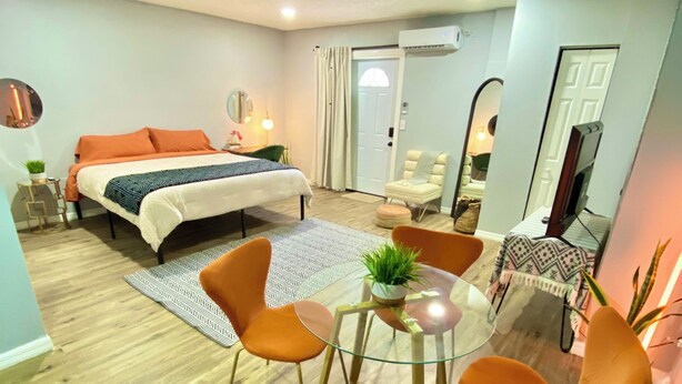 Ein modernes Schlafzimmer mit Bett, Nachttisch und einem kleinen Tisch mit Stühlen.