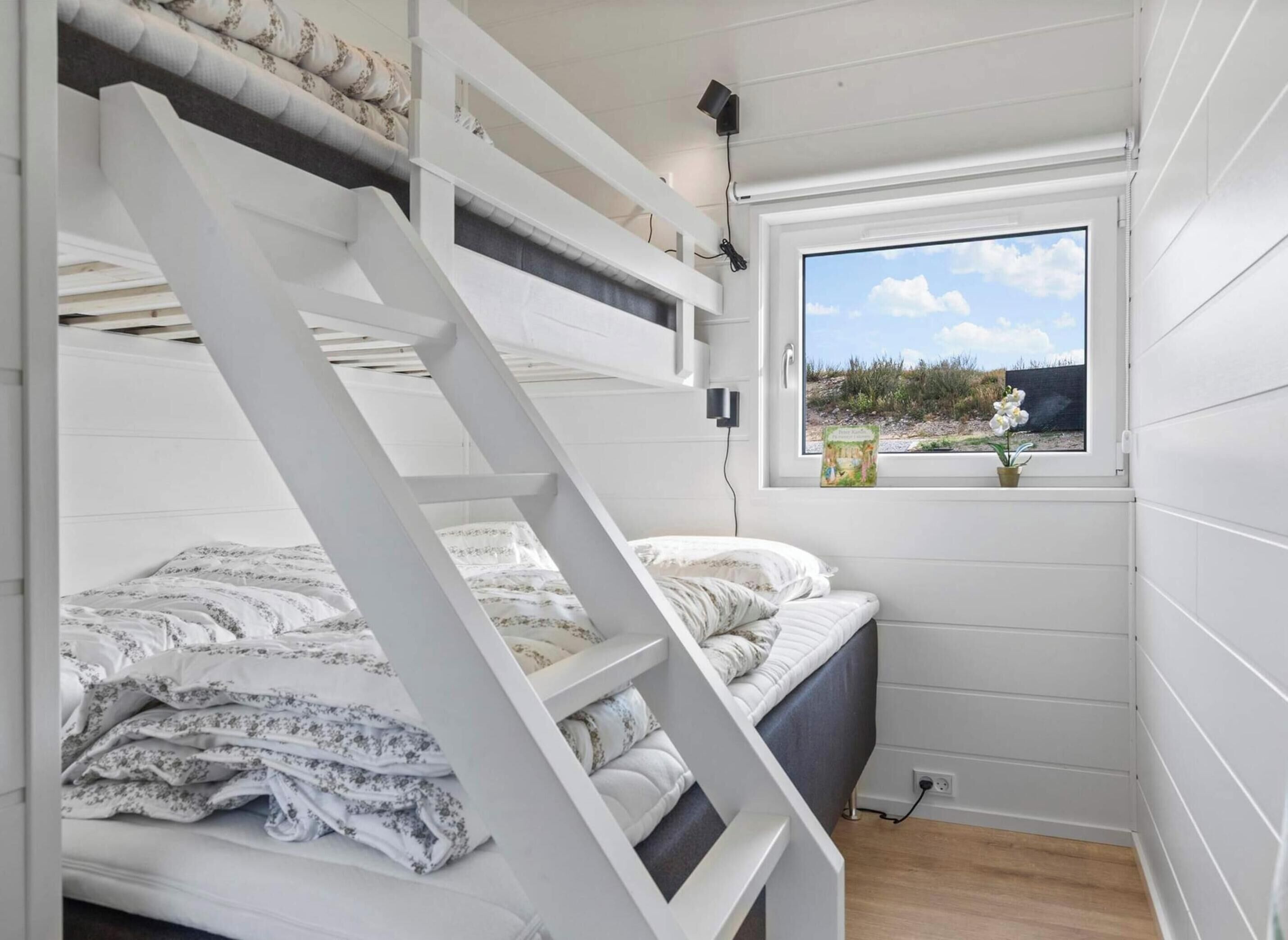 A bunk bed room with a window view of a landscape.