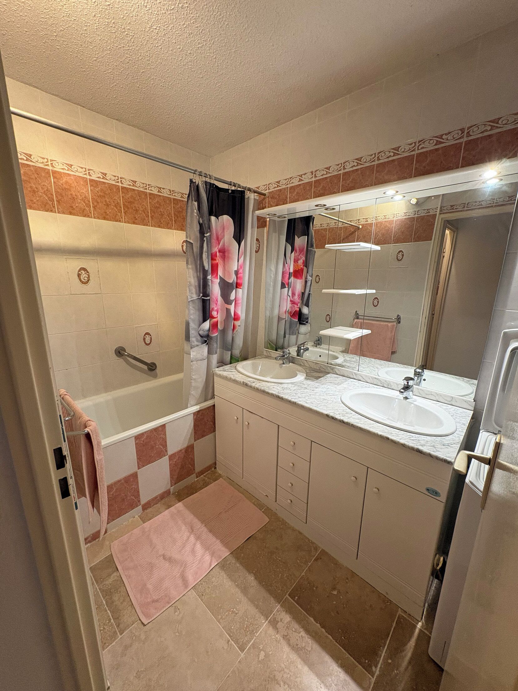 A bathroom with a bathtub, two sinks, a mirror, and a shower.