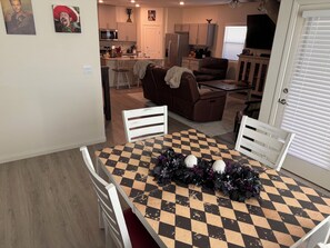 A dining area with a checkered table, two white chairs, and a decorative centerpiece.