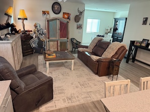 A living room with a brown leather sofa, a coffee table, and a patterned rug. - Super Clean new 1-Bd-1Bth N.Las Vegas, Aliante Casino, Golf, 15 min to Strip. (North Las Vegas)