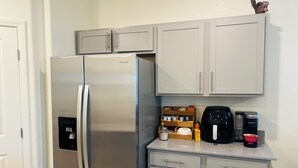 Eine Küche mit einem Edelstahl-Kühlschrank, einer Kaffeemaschine und einem Wasserspender.