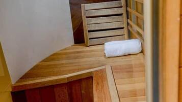 A wooden bench with a towel, a wooden ladder, and a metal door.