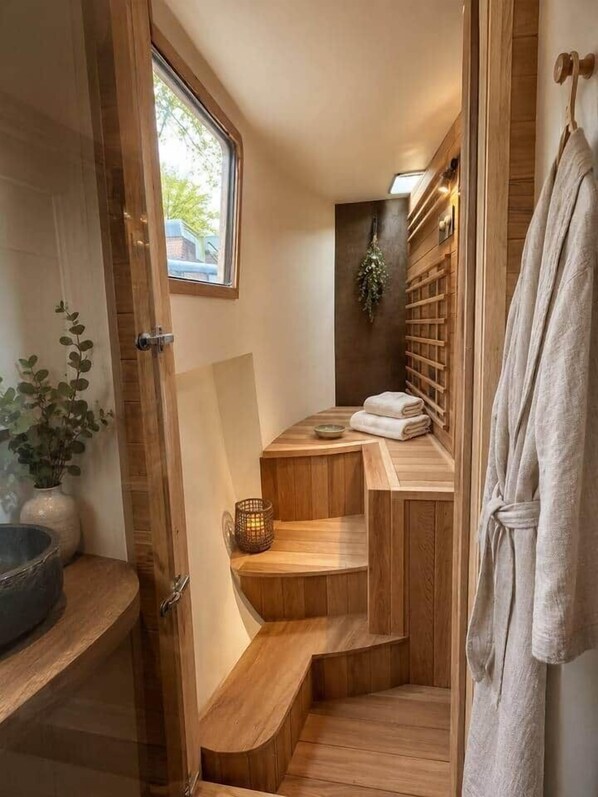 Un intérieur en bois avec une baignoire, un porte-serviettes et une fenêtre.