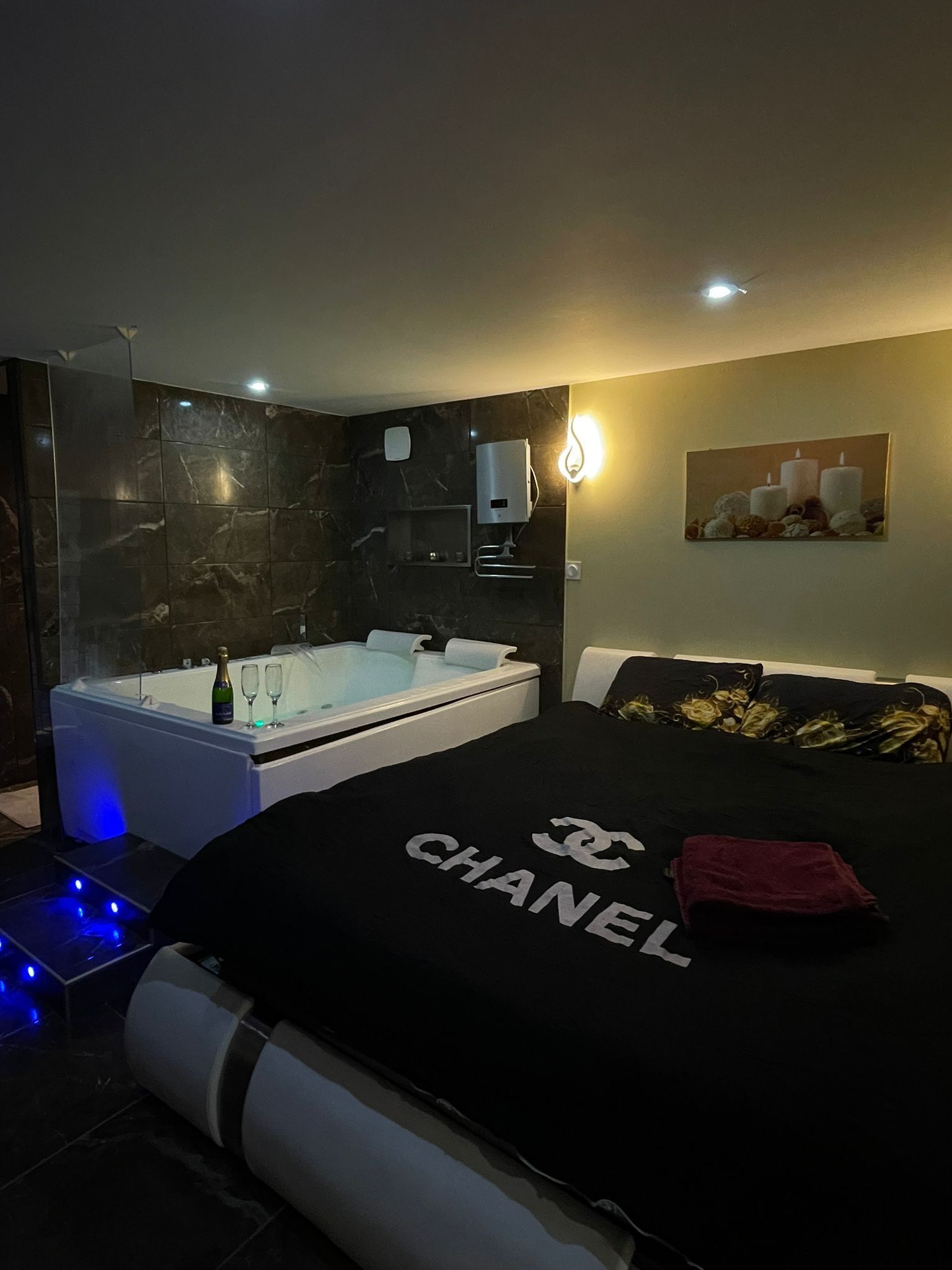 Une chambre à coucher moderne avec un grand lit, une baignoire et une cabine de douche en verre.