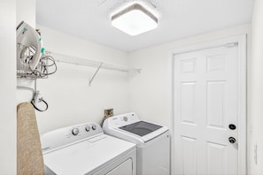 A laundry room with a washing machine, dryer, and a drying rack. - Disney Villa w/ Private Pool - 8 Mins to Disney (Kissimmee)