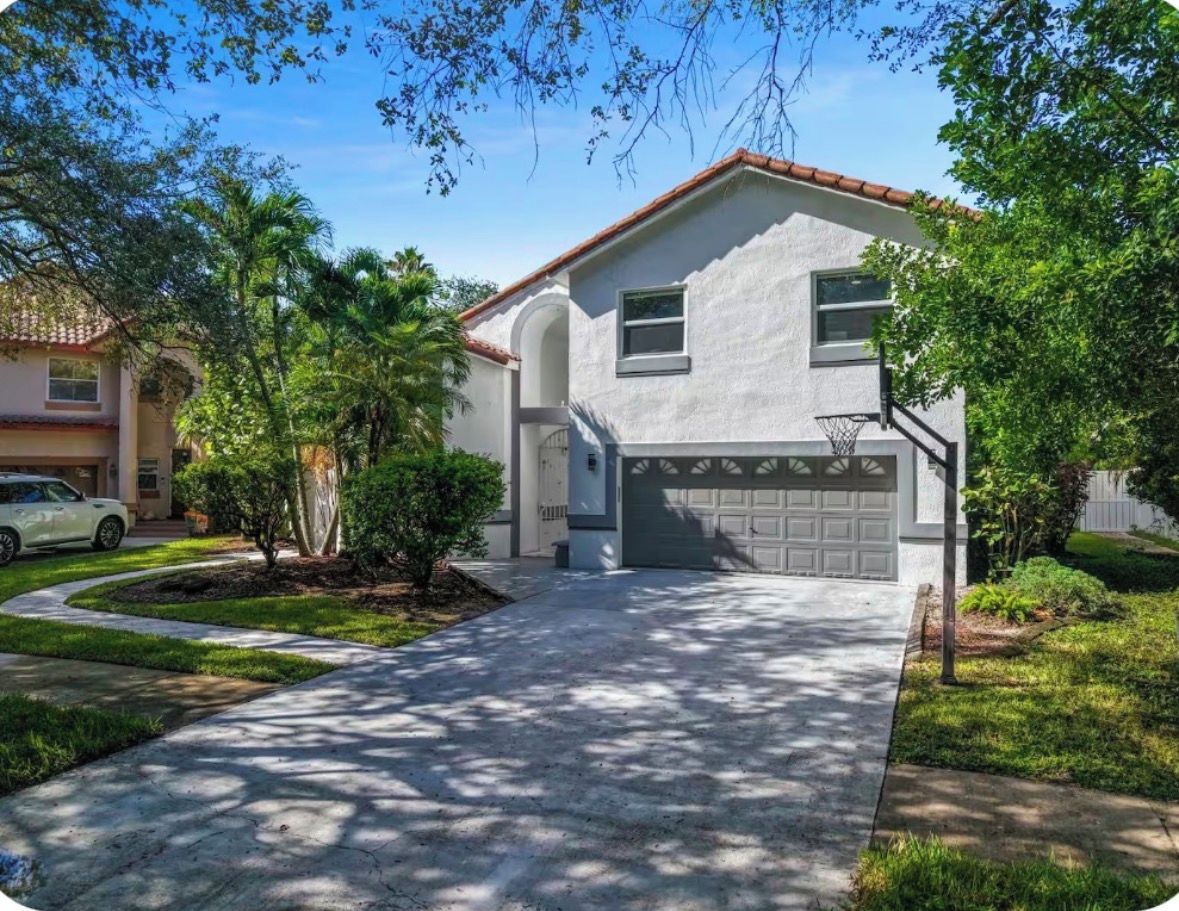 A residential house with a garage, a driveway, and a lawn.
