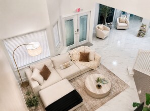 A modern living room with a sofa, coffee table, and a fireplace. - Luxury 5-bedroom house in Parkland perfect for family stays • Pool • Jacuzzi (Parkland)