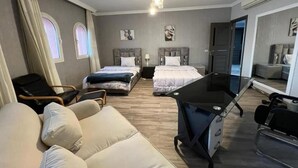 Una camera d'albergo con un letto, una scrivania, un divano e uno specchio.