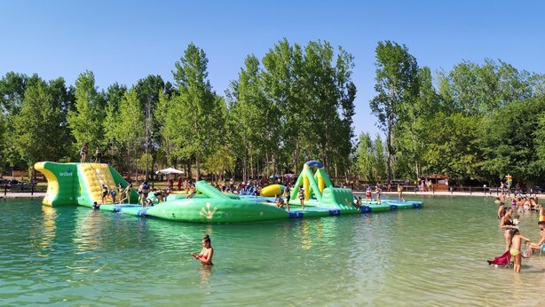 A water park with inflatable play structures and a clear sky.