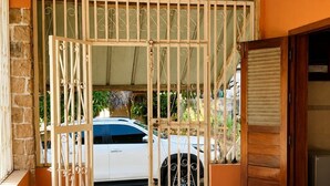 A spacious room with a tiled floor, a wooden ceiling, and a white car parked outside. - Amazing 3-bedroom house in pleasant Nosy Be perfect for relaxing getaway (nosy be)