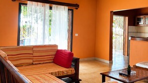A room with a wooden ceiling, a sofa with striped cushions, a small table, and a ceiling fan. - Amazing 3-bedroom house in pleasant Nosy Be perfect for relaxing getaway (nosy be)
