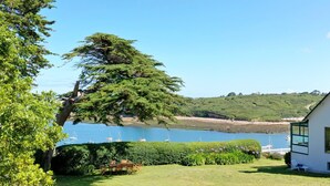 A house with a view of a lake and boats, surrounded by greenery and a hedge. - Superb Sea Views Private Beach Access (Saint-Pabu)